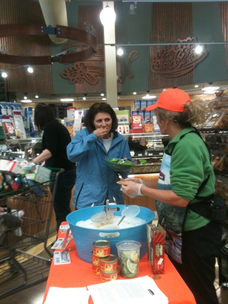 Serving salmon sample at Whole Foods Market